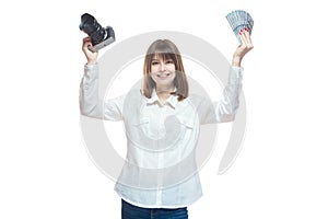 Portrait of a young woman in a white shirt holding a camera and US dollars in her hand. The concept of a successful