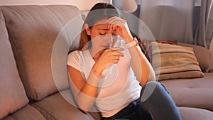 Portrait of young woman who crying and thinking about troubles on sofa in home iterior