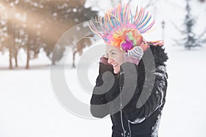 Portrait of young women with clown colorful wig and headphones o