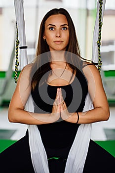 Portrait young women making antigravity yoga exercises. Aerial aero fly fitness trainer workout. white hammocks.