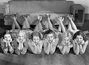 Portrait of young women in row on floor