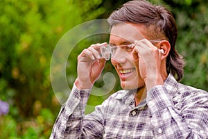 Portrait of young worker wearing transparent safety glasses, long sleeve shirt and ear plugs to protect from noise, in a