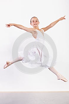 Portrait of youthful poise. a young ballerina leaping across the floor of a dance studio.