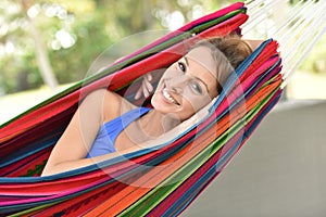 Portrait of yung woman lying in hammock and relaxing