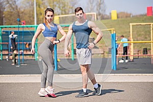 Portraits of a beautiful young athletic couple on the sport place