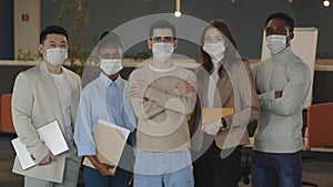 Portraits of business multicultural group standing at office with crossed arms wearing medical masks in order to protect