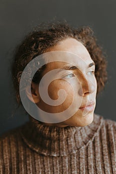 Portraits of a guy with an attractive appearance, curly hair and stylish clothes