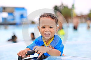 Portraits of happy little Asian baby boy smiling having fun at swimming pool outdoor