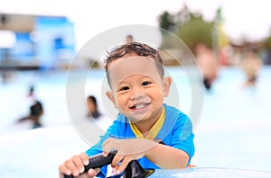 Portraits of little Asian baby boy smiling having fun in the pool outdoor