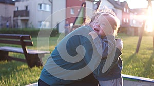 Portraits of a little beautiful boy with his mother outdoors. A boy is crying. A mom hugs him. Education, parenting