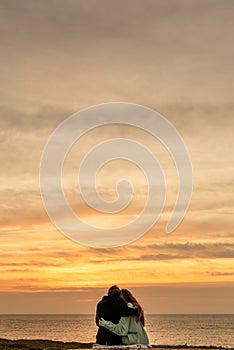 Portraits of lovers, romantic couple of lovers hugging, kissing, touching, eye contact at sunset, sunrise against the