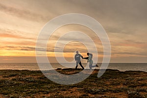 Portraits of lovers, romantic couple of lovers hugging, kissing, touching, eye contact at sunset, sunrise against the