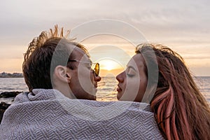 Portraits of lovers, romantic couple of lovers hugging, kissing, touching, eye contact at sunset, sunrise against the