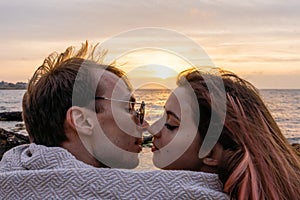 Portraits of lovers, romantic couple of lovers hugging, kissing, touching, eye contact at sunset, sunrise against the