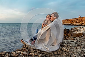 Portraits of lovers, romantic couple of lovers hugging, kissing, touching, eye contact at sunset, sunrise against the