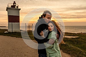 Portraits of lovers, romantic couple of lovers hugging, kissing, touching, eye contact at sunset, sunrise against the