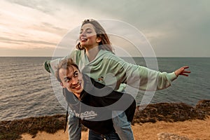 Portraits of lovers, romantic couple of lovers hugging, kissing, touching, eye contact at sunset, sunrise against the