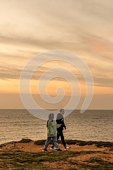 Portraits of lovers, romantic couple of lovers hugging, kissing, touching, eye contact at sunset, sunrise against the