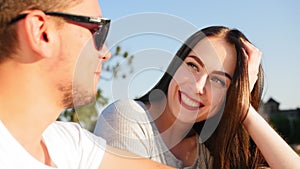 Portraits of a young cheerful couple. Romantic couple talking and sitting against the blue sky. Happy together. Close up