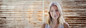 portraiture of woman smiling against blurry wood panel