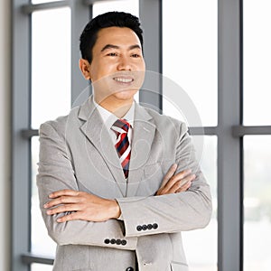 Portrat of businessman in suit posing in office whti self confident photo