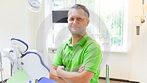Portrat of handsome male dentist posing in dental clinic