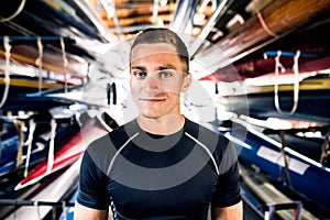 Portrat of young canoeist standing in the middle of stacked canoes. Concept of canoeing as dynamic and adventurous sport photo