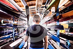 Portrat of young canoeist standing in the middle of stacked canoes. Concept of canoeing as dynamic and adventurous sport photo