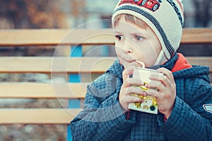 Portreit of a little boy drinking juice