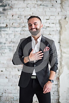 Portreit of man in black suit .on a  brick background