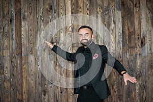 Portreit of man in black suit .on a wood background