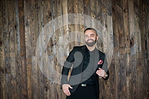 Portreit of man in black suit .on a wood background