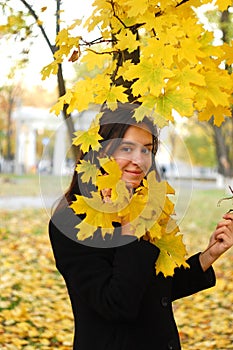 A portret of happy young attractive girl in an autumn park. Cheerful emotions, autumn mood