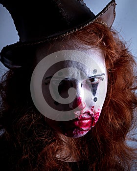 Portriat of a Young woman ins scary clown make up.