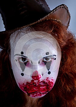 Portriat of a Young woman ins scary clown make up.