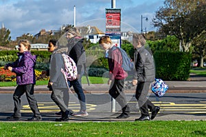 A group of British school children walking past a bus stop