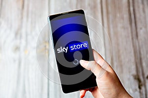 03-22-2021 Portsmouth, Hampshire, UK A mobile phone or cell phone being held in a hand with the Sky Store app open on screen