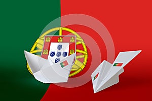 Portugal flag depicted on paper origami airplane and boat. Handmade arts concept