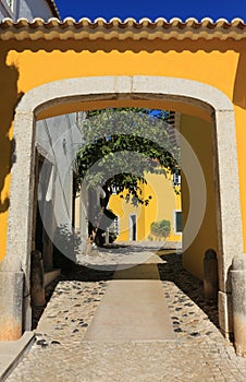 Portugal, Lisbon, Oeiras. Typical old arched gateway and yellow facade