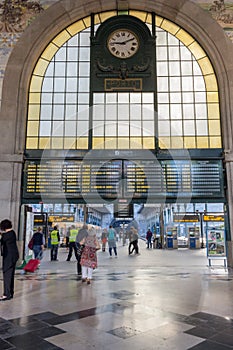 Portugal, Porto - 10/22/2018: central railway station with timetable, clock and tourists. Hall of famous Sao Bento train station.