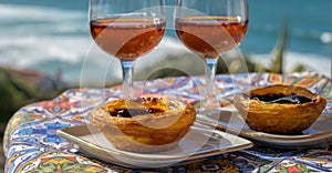 Portugal`s traditional food and drink, glasses of porto wine or muscatel de setubal and sweet dessert Pastel de nata egg custard