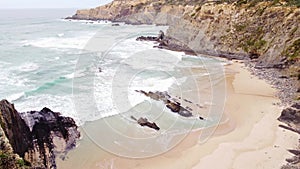 Portugal\'s west coast with sandy beaches and a clear Atlantic Ocean with soft light warming the sand