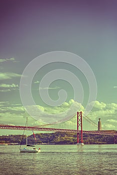 Portugal Travel Ideas. One White Sailing Boat With Group of Tourist on Tagus River Under 25th of April Bridge in Lisbon in