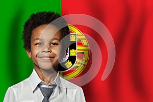 Portugese kid boy on flag of Portugal background. Education and childhood concept