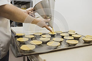 Portuguese baker making pastel de nata, Portuguese custard tarts photo