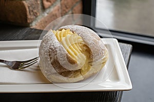 Portuguese doughnut or Berliner with egg creme over a white plate