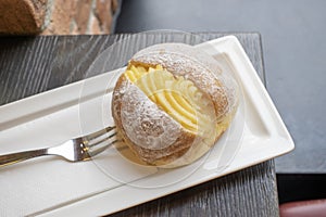 Portuguese doughnut or Berliner with egg creme over a white plate