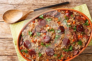 Portuguese duck rice arroz de pato cooked with red wine, onion, carrot and chorizo close up in the baking dish. Horizontal top photo