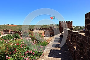 The Portuguese flag flying over the castle battlements at Silves