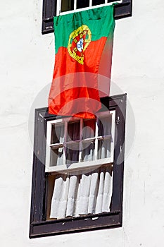 Portuguese flag hanging from old portuguese windows